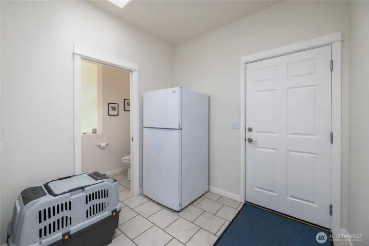 Door at the right leads to the attached garage.  Large mudroom/drop zone has tile floor, and a 1/2 bath powder room and laundry room off of it.
