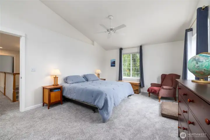 The primary suite is a sanctuary - vaulted ceiling with ceiling fan, lots of natural light, a walk-in closet, and spacious 5 piece bath.
