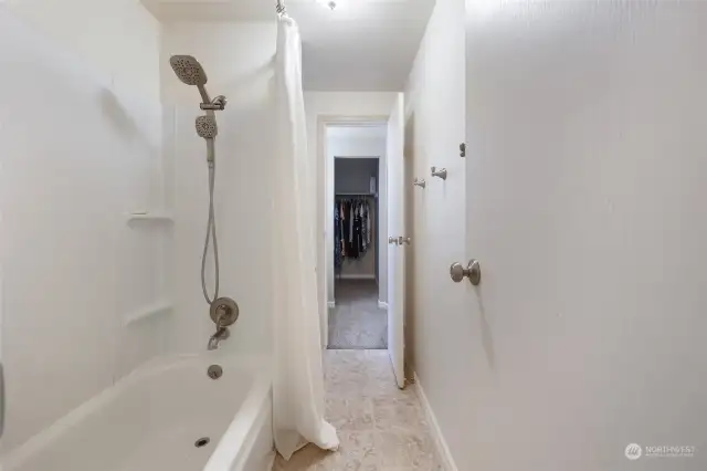 Bath/shower combo (with commode ahead on the left) shared between bedrooms, with doors to each vanity/closet.