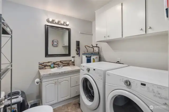 Multi-purpose half bath offers matching washer & dryer and practical storage.