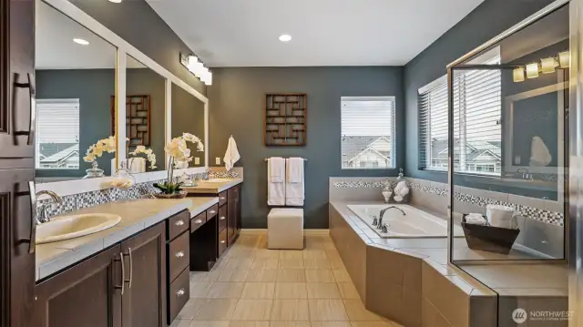 The primary bath is stylish and spacious.  A full soak tub and large glass shower plus beautiful tile counters and floors.