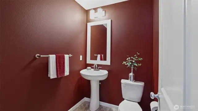 The powder room has a pedestal sink and custom paint plus luxury vinyl.