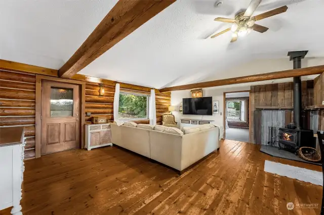 Warm & open log cabin -experience the natural beauty of hardwood floors and exposed beams, complemented by a classic wood stove for the perfect rustic escape.