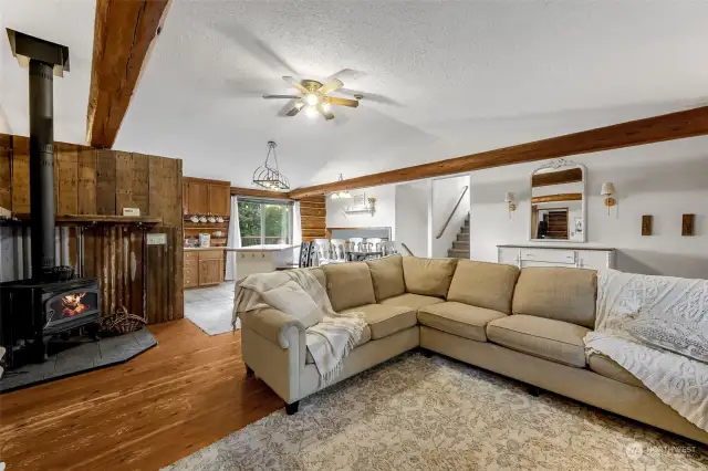 Enjoy the cozy ambiance of the wood stove in the expansive living area, complete with hardwood floors and exposed wood beams that add timeless character.