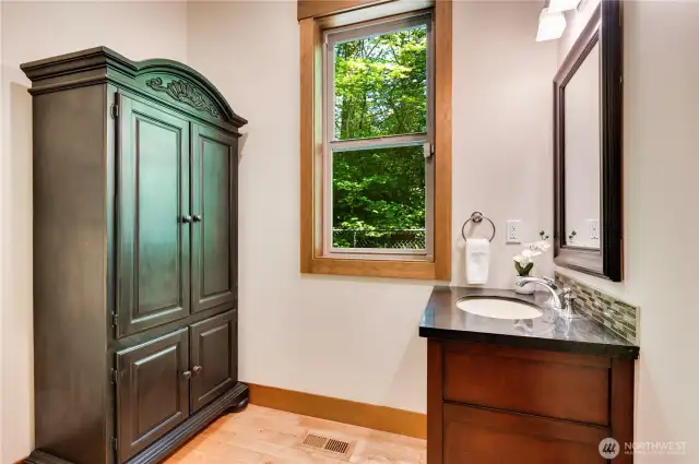 Downstairs powder room features a cherry cabinet and granite counters.
