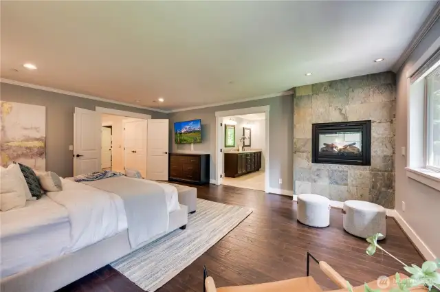 Primary bedroom is a true retreat with a cozy double-sided fireplace.