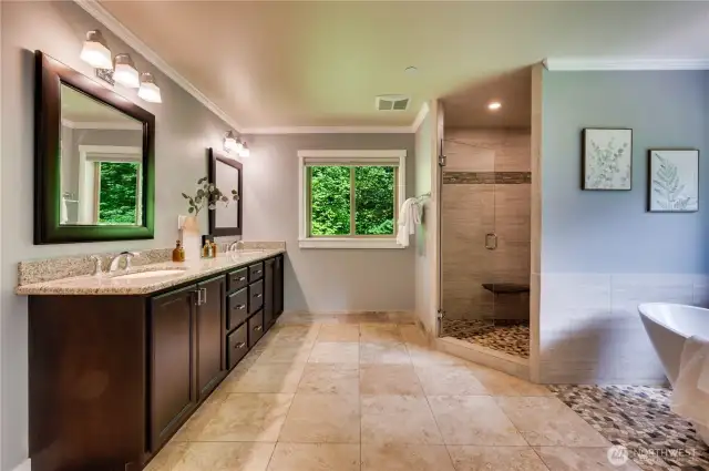 Organic and elegant Primary bathroom with travertine floors and expresso cabinets.