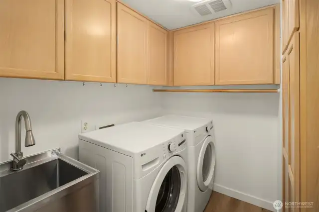 Conveniently located on the main floor, the laundry area features ample cabinet storage and a dedicated washing sink for added functionality.