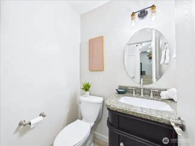 A powder room is conveniently located on the main floor for your guests to use. Nice dark vanity with granite countertop.