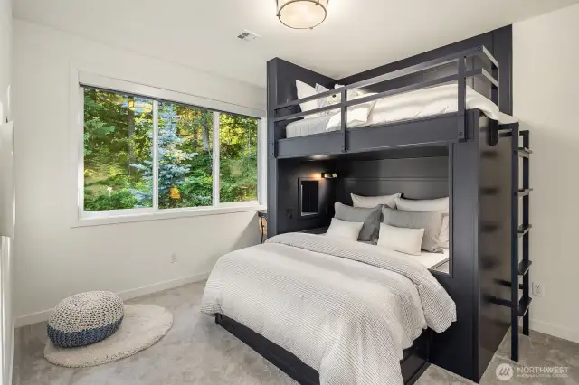 A unique bedroom offering custom-built bunk beds, queen on bottom and twin on top, as well as an integrated desk—perfect for work and play