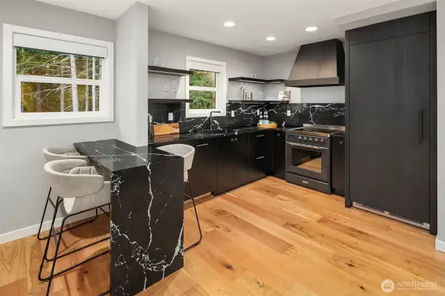 High-end appliances include a Perlick refrigerator, Hestan dishwasher, Majestic II induction range, custom oil-rubbed bronze designer hood, and bespoke cabinetry. Remarkably, this is the second kitchen
