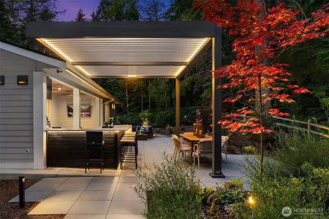 Exterior lighting creates a dramatic ambiance, perfect for evening entertaining