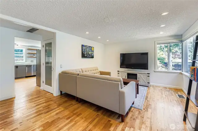 Large living room with beautiful hardwood floors, multiple options for a seating area (maybe two!), continuance of recess lighting, and more corner windows - you'll love hanging out here.
