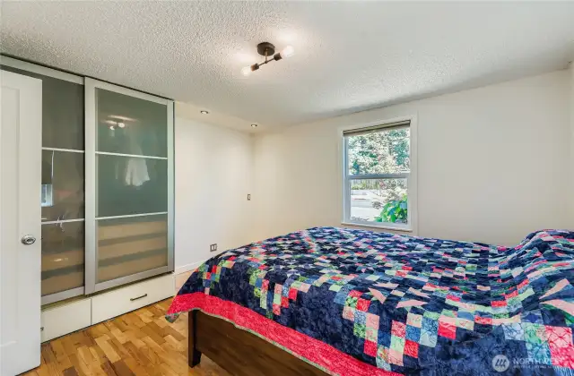 Bedroom sports modern glass closet doors for an updated vibe.