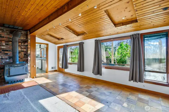Living room with large windows that let in natural light and gorgeous cedar plank ceilings