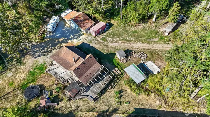 Aerial photo of property with large home, garage, sheds, ample space for RV parking, gardening, etc.