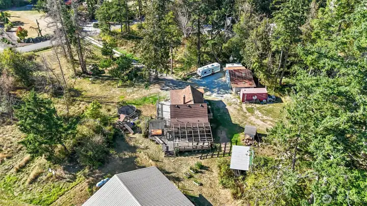 Aerial photo of property with large home, garage, sheds, ample space for RV parking, gardening, etc.