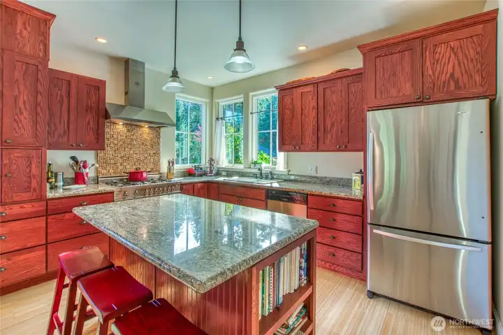 the large kitchen island provides dining space to interact with the chef! Granite countertops make for easy cleanup.