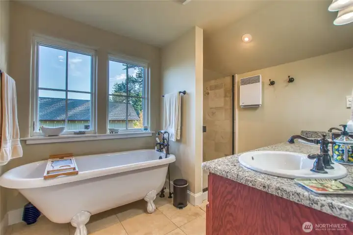 The large bathroom is graced with a claw-foot tub and a double vanity.
