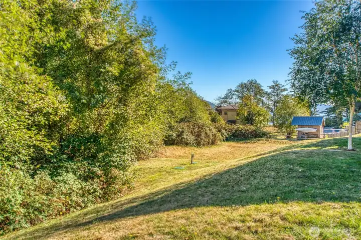 The common area lawn has a path at the base of the slope leading to town.