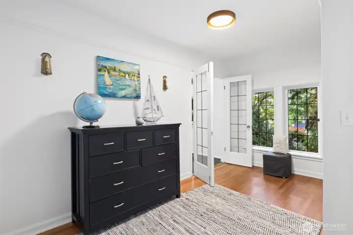 This bedroom features a spacious play area, a cutout with French doors leading to a sleeping nook, and an en suite bathroom for convenience and privacy.