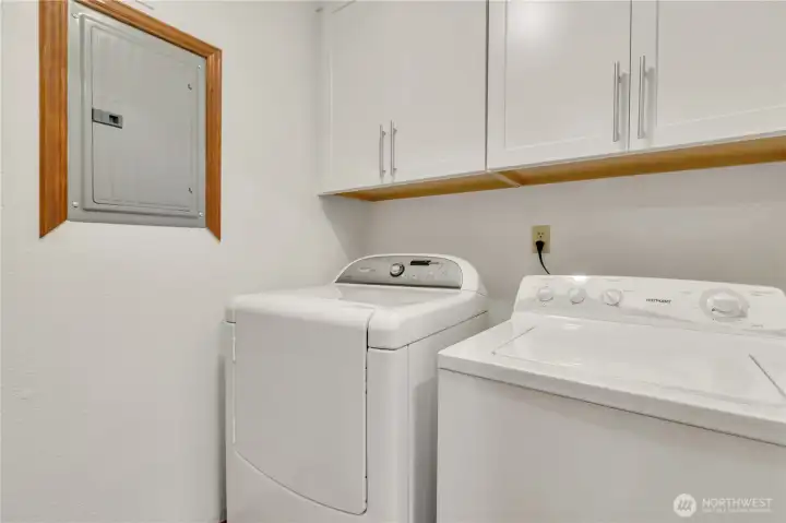 The utility room is equipped with a washer and dryer plus storage.