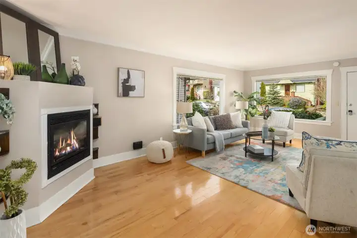 Main floor living room with great natural light, gleaming hardwood floors and an inviting gas fireplace