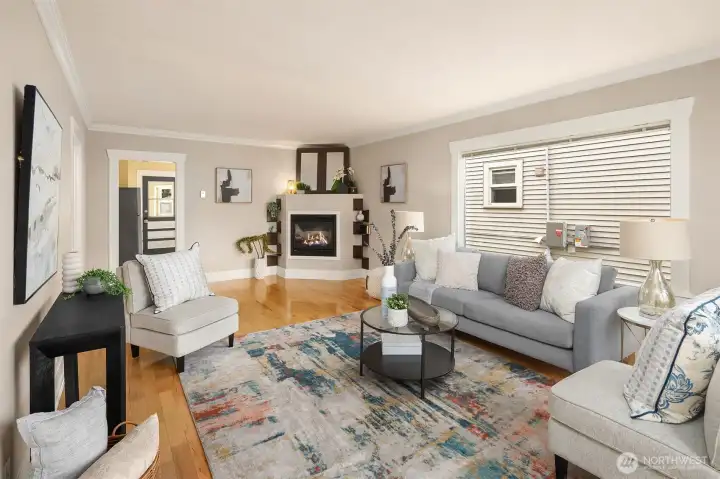 Main floor living room with great natural light, gleaming hardwood floors and an inviting gas fireplace