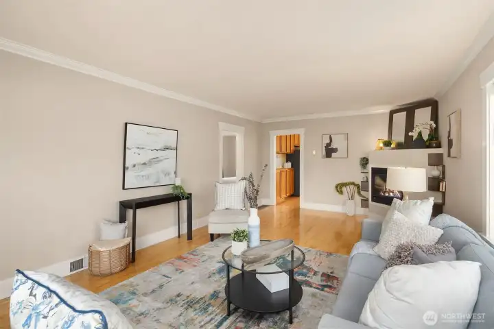 Main floor living room with great natural light, gleaming hardwood floors and an inviting gas fireplace