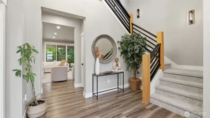 Enter to the den (or main floor bedroom) on the left and the stairs to your right. Additional features include LVP flooring, quartz surfaces throughout, tankless water heater, and gas furnace with heat pump.