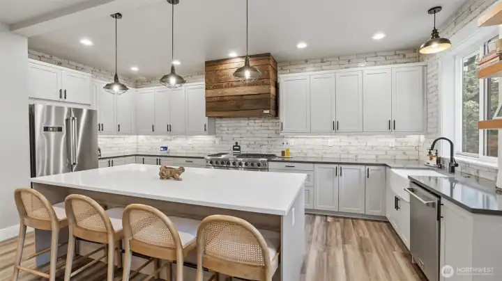 Don't miss the rustic, custom hood over the commercial grade stove!