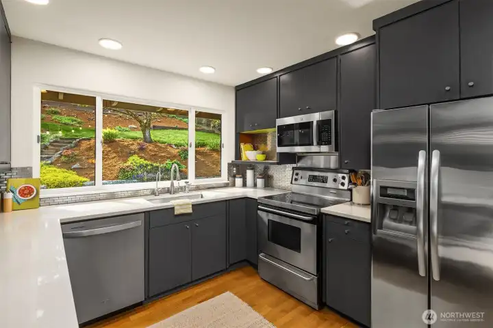The updated kitchen overlooks the backyard and features quartz contertops and stainless appliances.