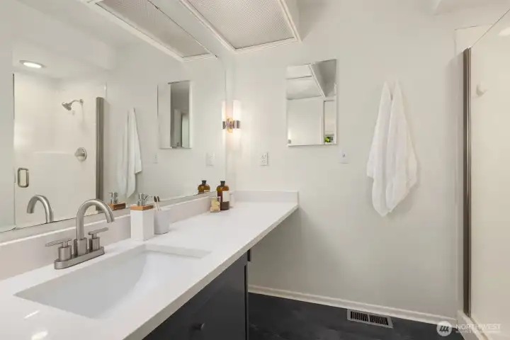 En-suite primary bathroom featuring beautiful quartz countertop and walk-in shower.