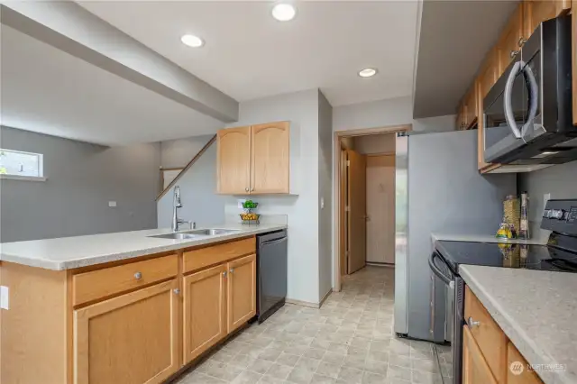 Kitchen connects to utility room with half bath, door to garage