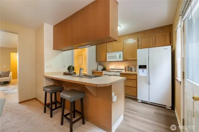 The kitchen has an eat-in counter and appliances that stay!