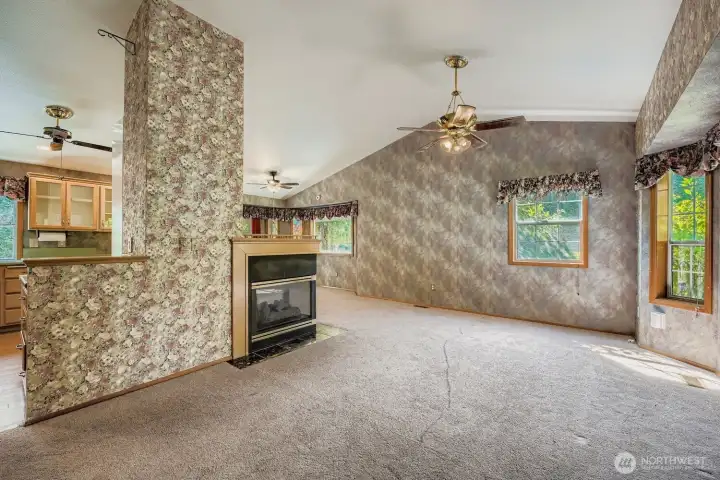 The living room has abundant natural light, vaulted ceilings and a double see through fireplace from the living room into the dining room.