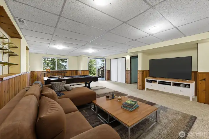 Heading downstairs you will come into a large bonus room area with slider doors out to the back patio and stairs that go up to the top deck. Oh so many uses for the space  in this room-virtually staged