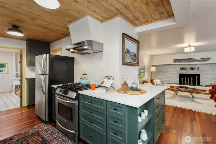 Yummy green cabinets, stainless appliances and zellige tile backsplash.