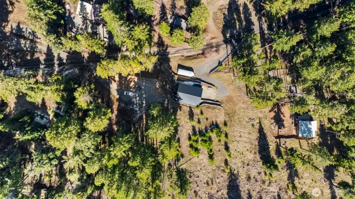 Aerial view showcasing wooded acreage and peaceful Sky Meadows Ranch setting.