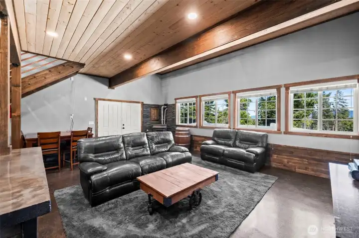 living area with open flow and vaulted wood ceilings.