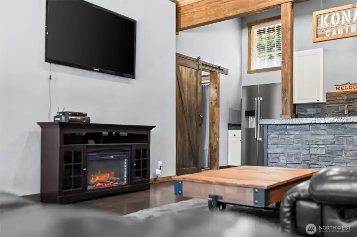 Living area with electric stove creating a warm and cozy mountain cabin feel.