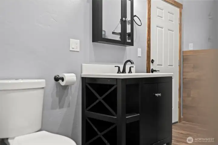 Bathroom with modern vanity, storage, and updated fixtures.