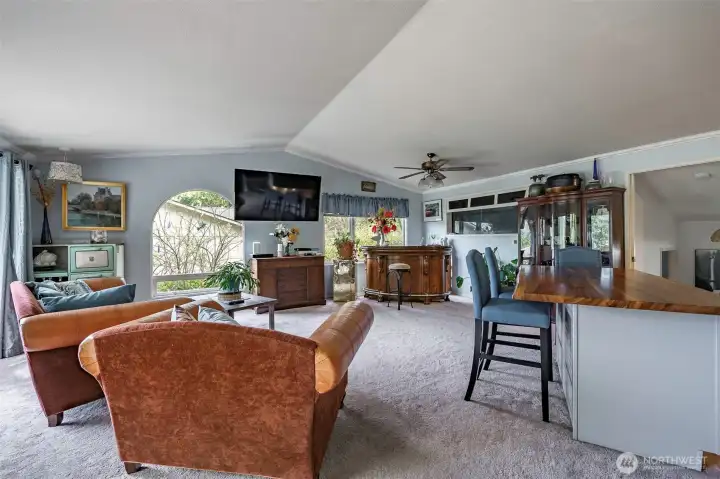 A striking live-edge island brings warmth and character to the dining space, while a bar area and a 125-gallon in-wall aquarium add a distinctive and inviting touch.