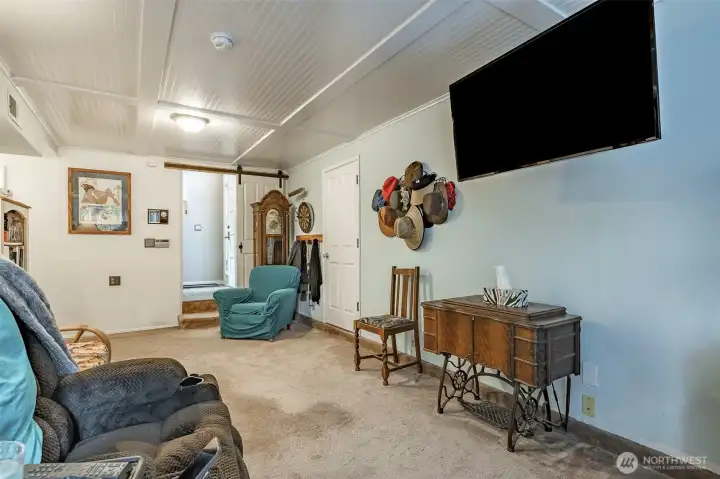 Lower downstairs family room featuring a thoughtfully designed ceiling that adds depth and texture to the space.