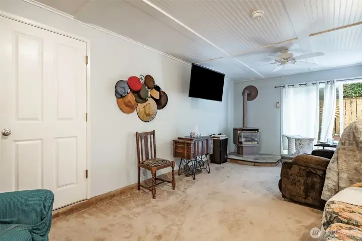 Another view of the lower downstairs family room with free-standing gas fireplace. Door in front leads to the 3-car garage.