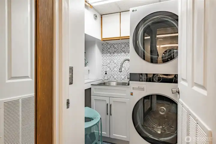 Laundry room comes complete with a new washer and dryer along with tile adding great appeal.