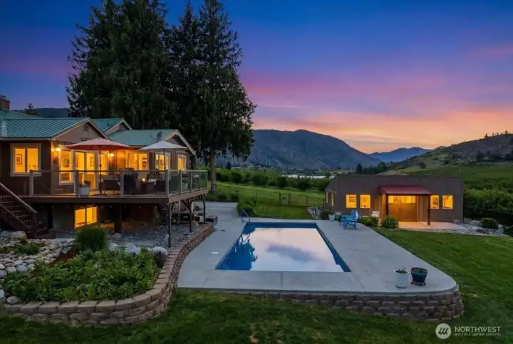 Twilight exterior of home pool and hobby shop