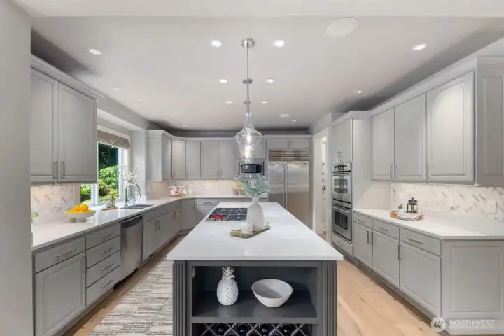 Refined kitchen with quartz surfaces, marble herringbone splash, and Wolf and Sub-Zero appliances. Refined kitchen with quartz surfaces, marble herringbone splash, and Wolf and Sub-Zero appliances.