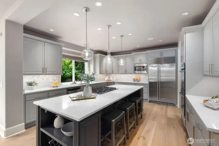 Refined kitchen with quartz surfaces, marble herringbone splash, and Wolf and Sub-Zero appliances. Refined kitchen with quartz surfaces, marble herringbone splash, and Wolf and Sub-Zero appliances.