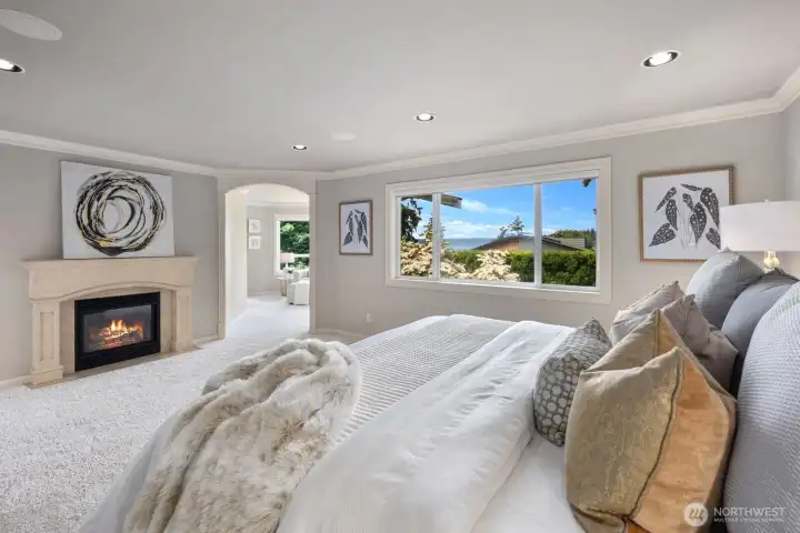 A serene primary suite with lake views, gas fireplace and a private sitting and dressing area. A serene primary suite with lake views, gas fireplace and a private sitting and dressing area.